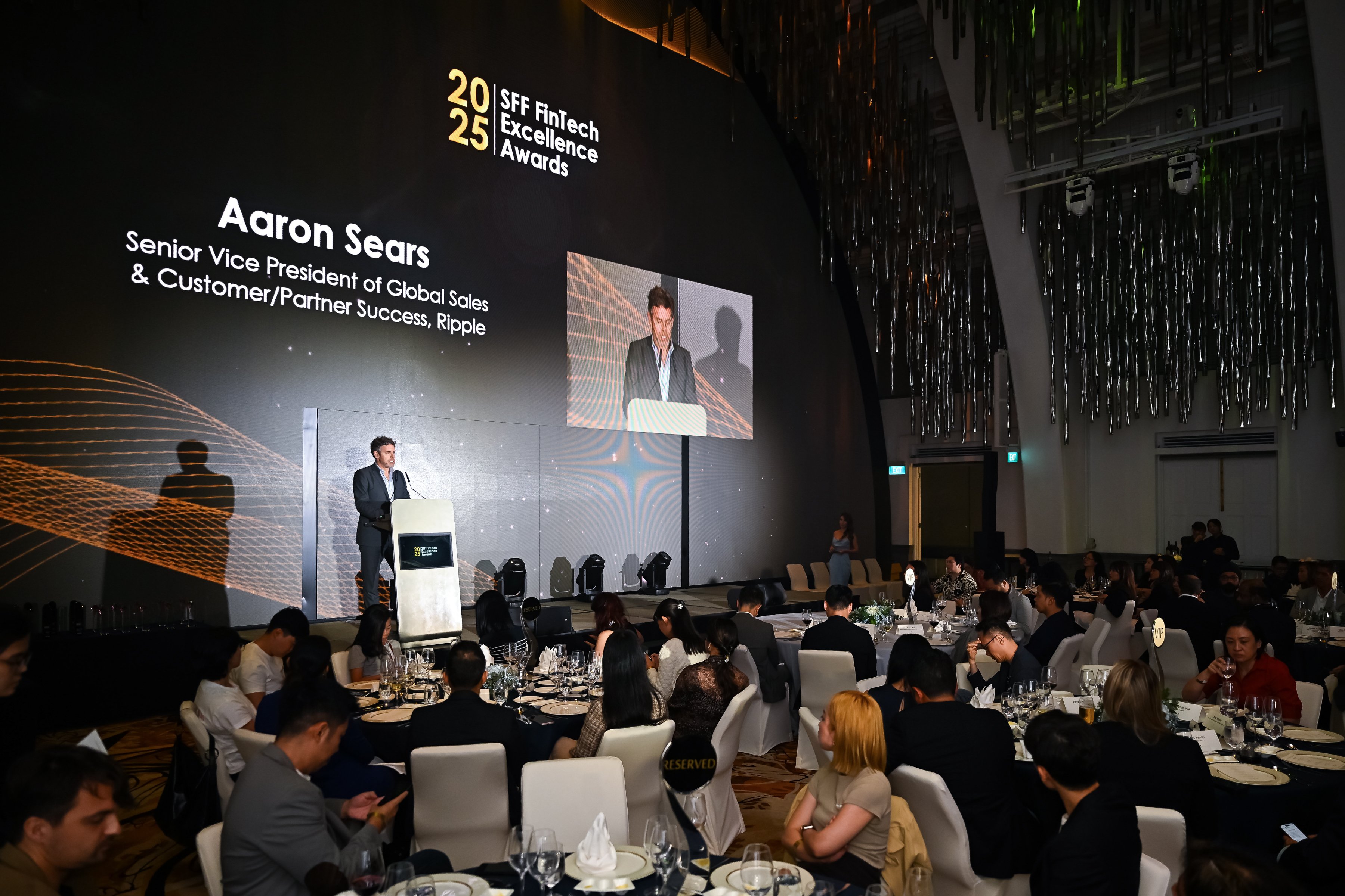 A speaker addresses guests seated at dinner tables during the SFF FinTech Excellence Awards 2025 ceremony in Singapore