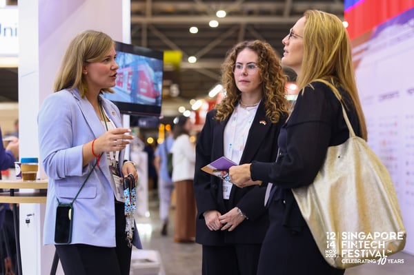 Three delegates talking in the exhibition hall