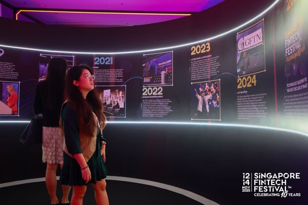 Two visitors reading a timeline wall of past festivals