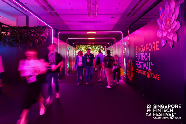 Delegates walking through a pink neon festival tunnel