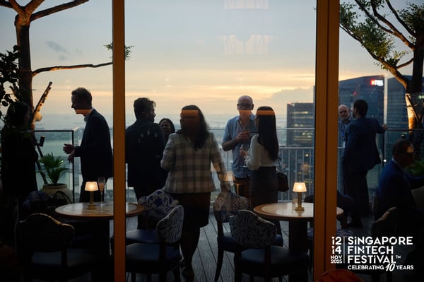 Delegates on a rooftop terrace at sunset