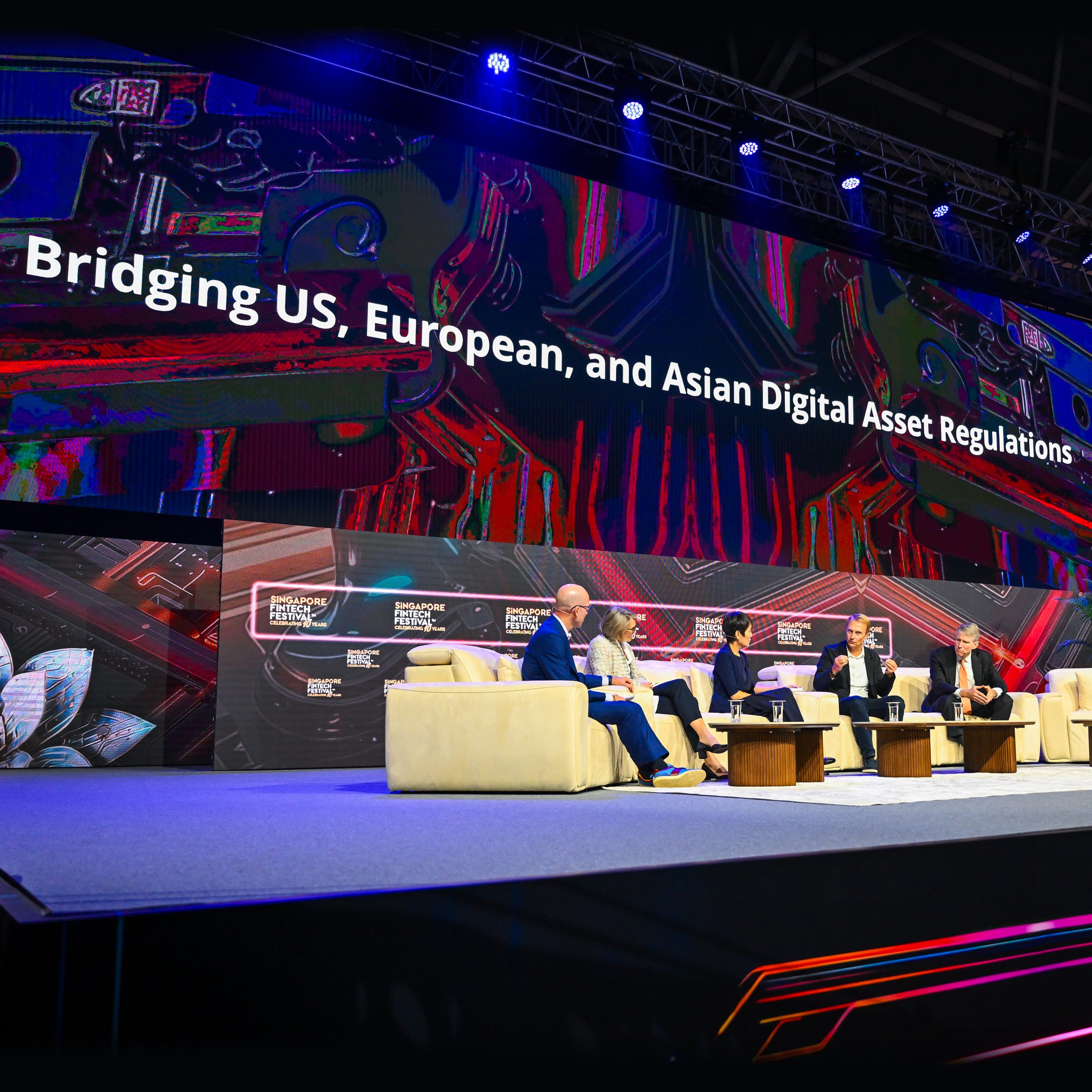 Five panellists on the main stage beneath the session title Bridging US, European, and Asian Digital Asset Regulations